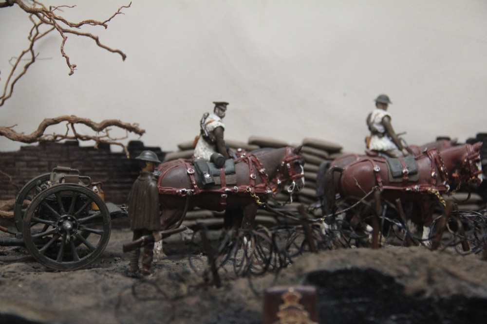 A glazed wooden display case containing an early 20th-century military diorama of a horse-drawn artillery team on a WWI battlefield scene. View III