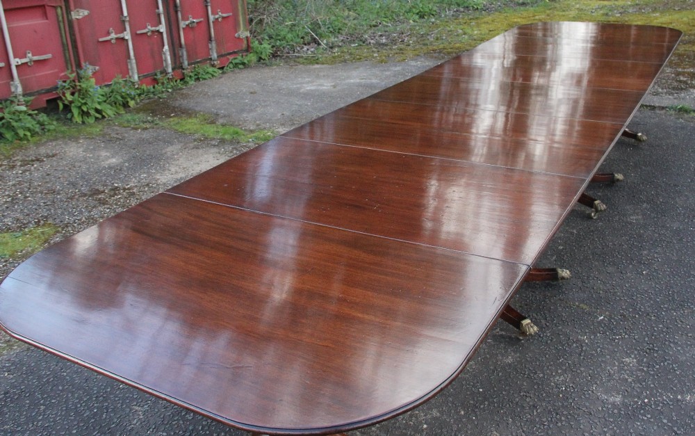 An exceptionally long early twentieth-century mahogany dining table supported by four turned central pedestals with splayed legs ending in brass paw castors. View VII