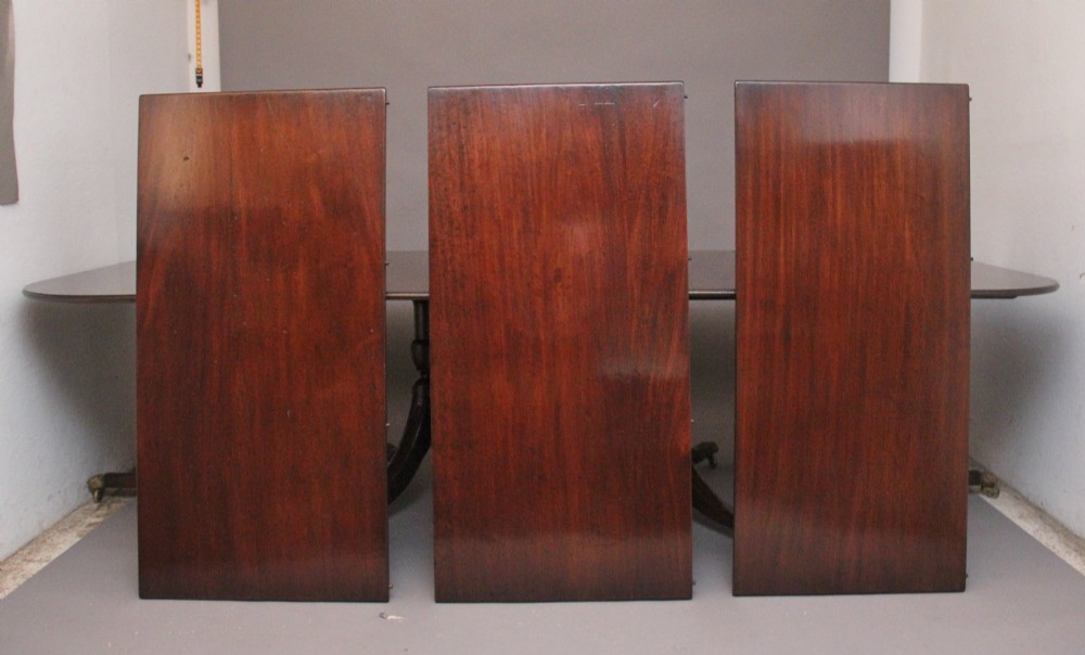 An exceptionally long early twentieth-century mahogany dining table supported by four turned central pedestals with splayed legs ending in brass paw castors. View VIII