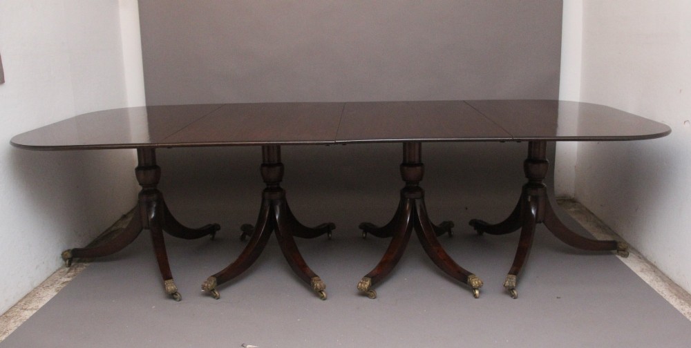 An exceptionally long early twentieth-century mahogany dining table supported by four turned central pedestals with splayed legs ending in brass paw castors. View IX