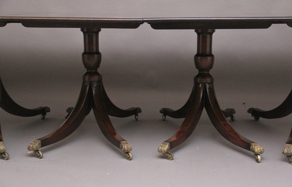 An exceptionally long early twentieth-century mahogany dining table supported by four turned central pedestals with splayed legs ending in brass paw castors. View X