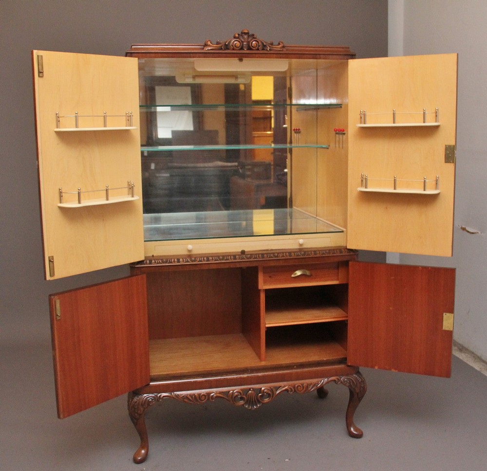 An early 20th-century burr walnut drinks cabinet with decorative pierced brass strap hinges, double doors, and carved cabriole legs. View II