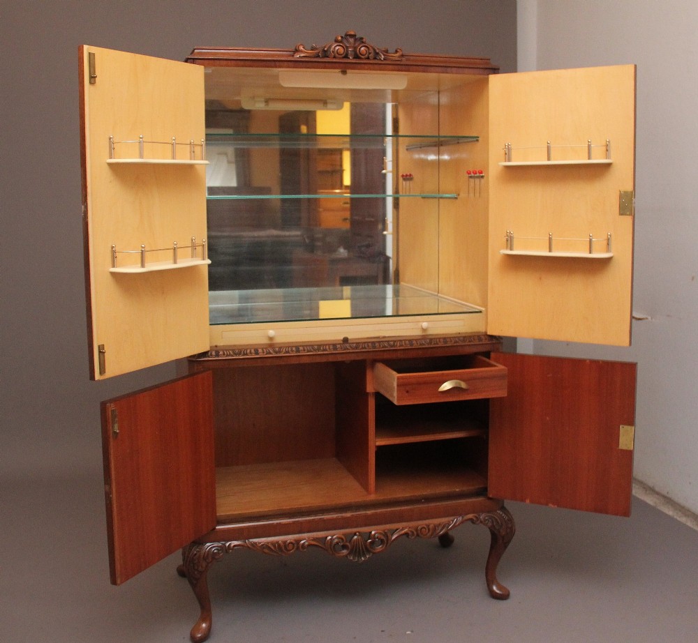 An early 20th-century burr walnut drinks cabinet with decorative pierced brass strap hinges, double doors, and carved cabriole legs. View III