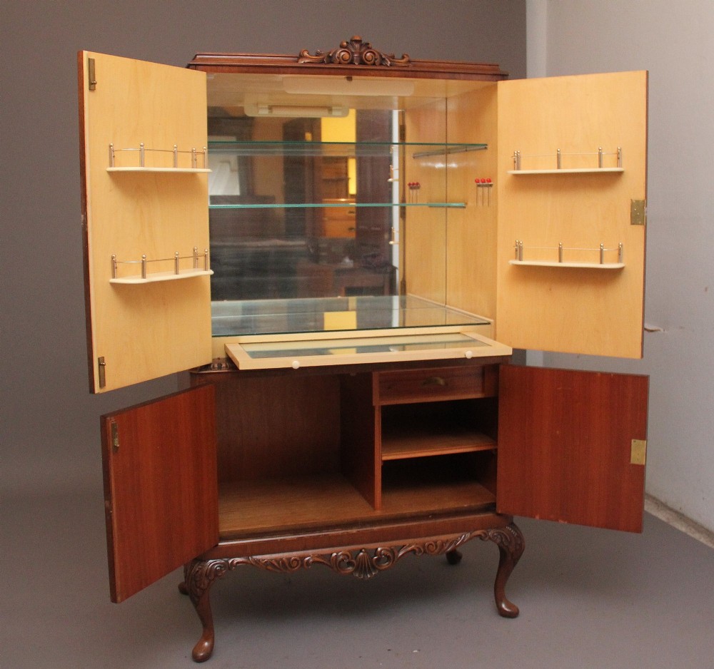 An early 20th-century burr walnut drinks cabinet with decorative pierced brass strap hinges, double doors, and carved cabriole legs. View IV