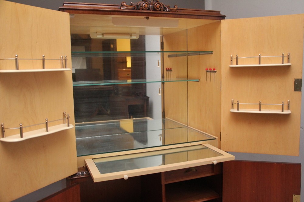 An early 20th-century burr walnut drinks cabinet with decorative pierced brass strap hinges, double doors, and carved cabriole legs. View V