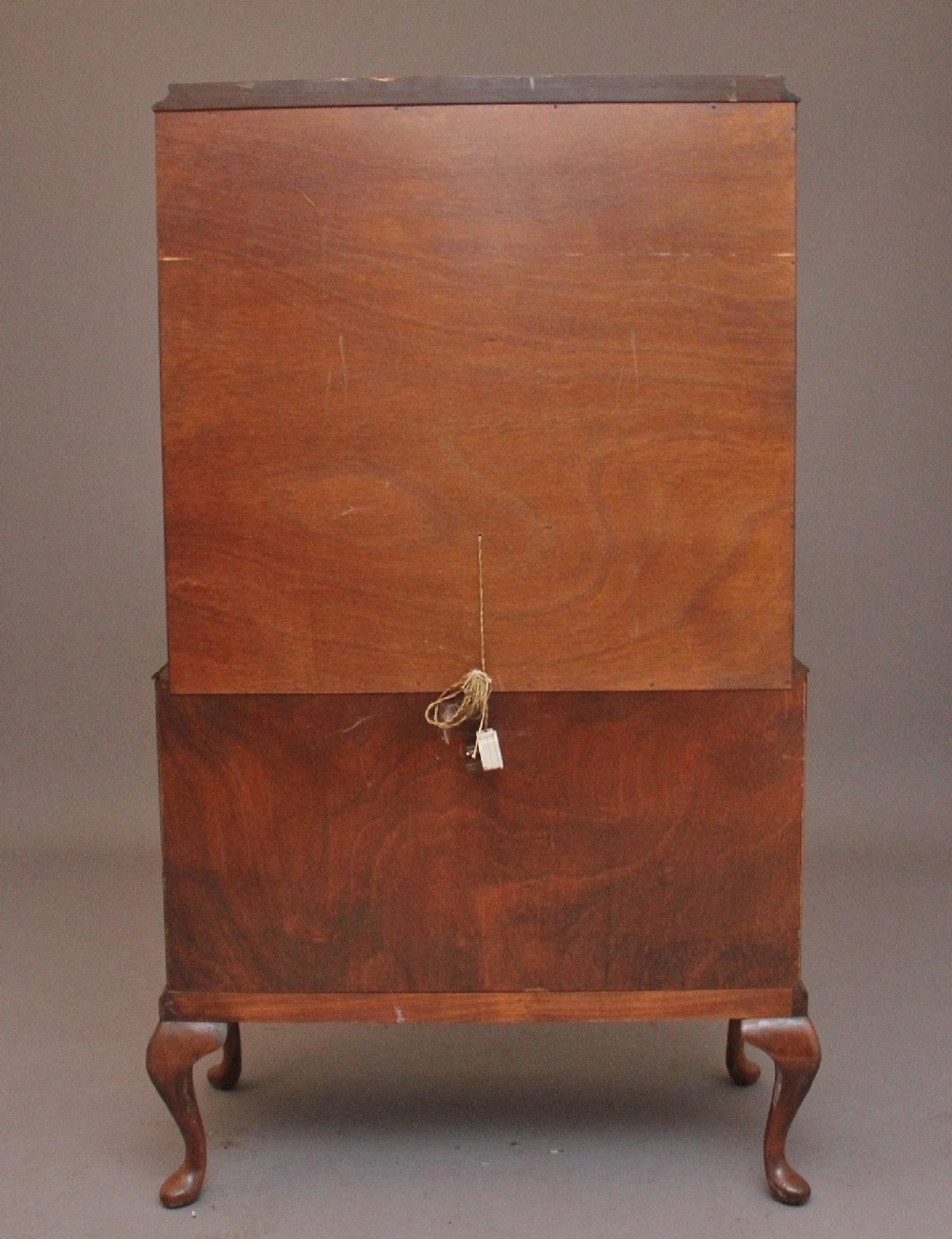 An early 20th-century burr walnut drinks cabinet with decorative pierced brass strap hinges, double doors, and carved cabriole legs. View XII