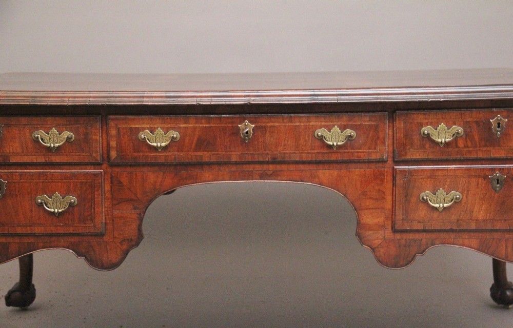 A 19th-century walnut writing desk featuring multiple drawers with brass hardware, a shaped apron, and carved cabriole legs with ball-and-claw feet. View VI