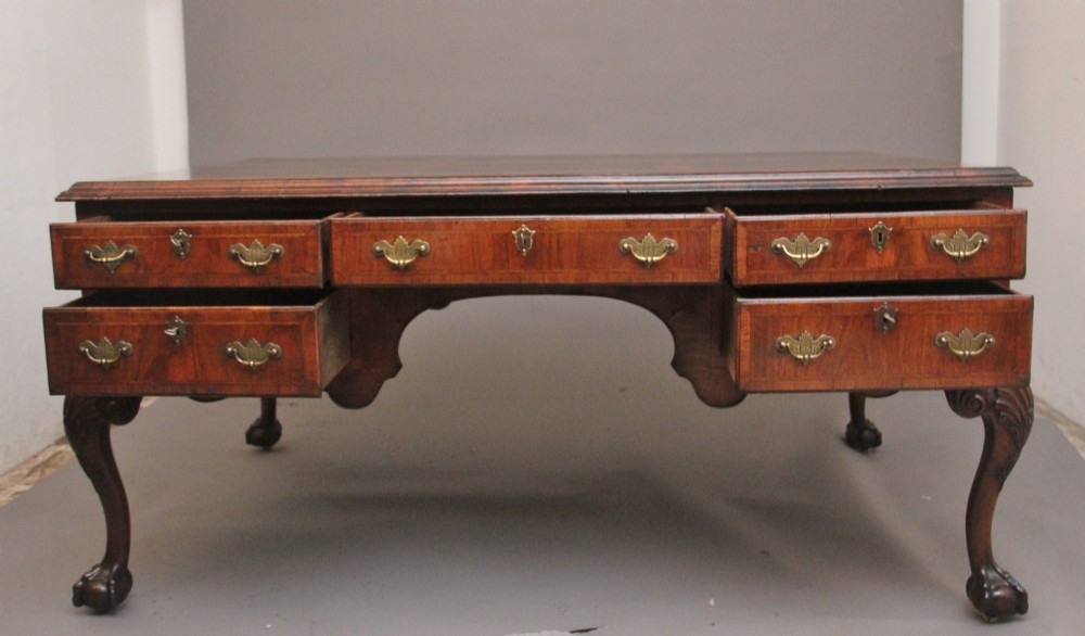 A 19th-century walnut writing desk featuring multiple drawers with brass hardware, a shaped apron, and carved cabriole legs with ball-and-claw feet. View XIV