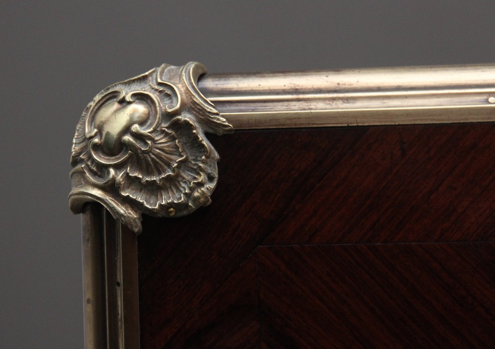 A 19th-century French kingwood writing desk with cabriole legs, ornate gilt-bronze ormolu mounts, three frieze drawers, and a dark inset leather writing top. View XI