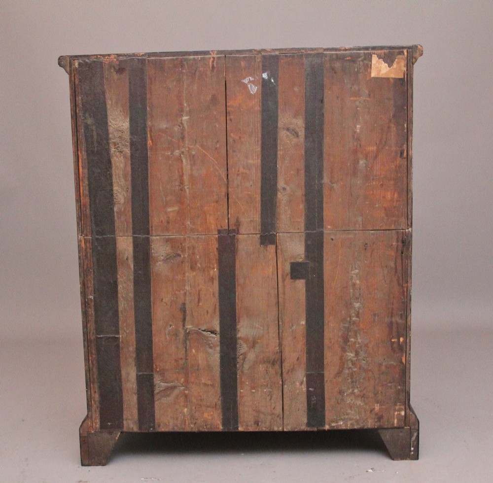 An early 18th-century George II walnut chest of drawers featuring crossbanded drawer fronts, brass handles, a central cupboard door, and bracket feet. View IX