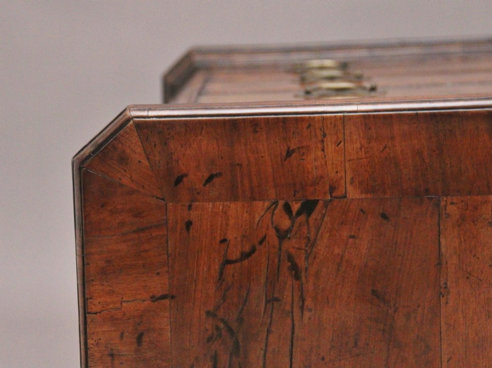 An early 18th-century George II walnut chest of drawers featuring crossbanded drawer fronts, brass handles, a central cupboard door, and bracket feet. View XII