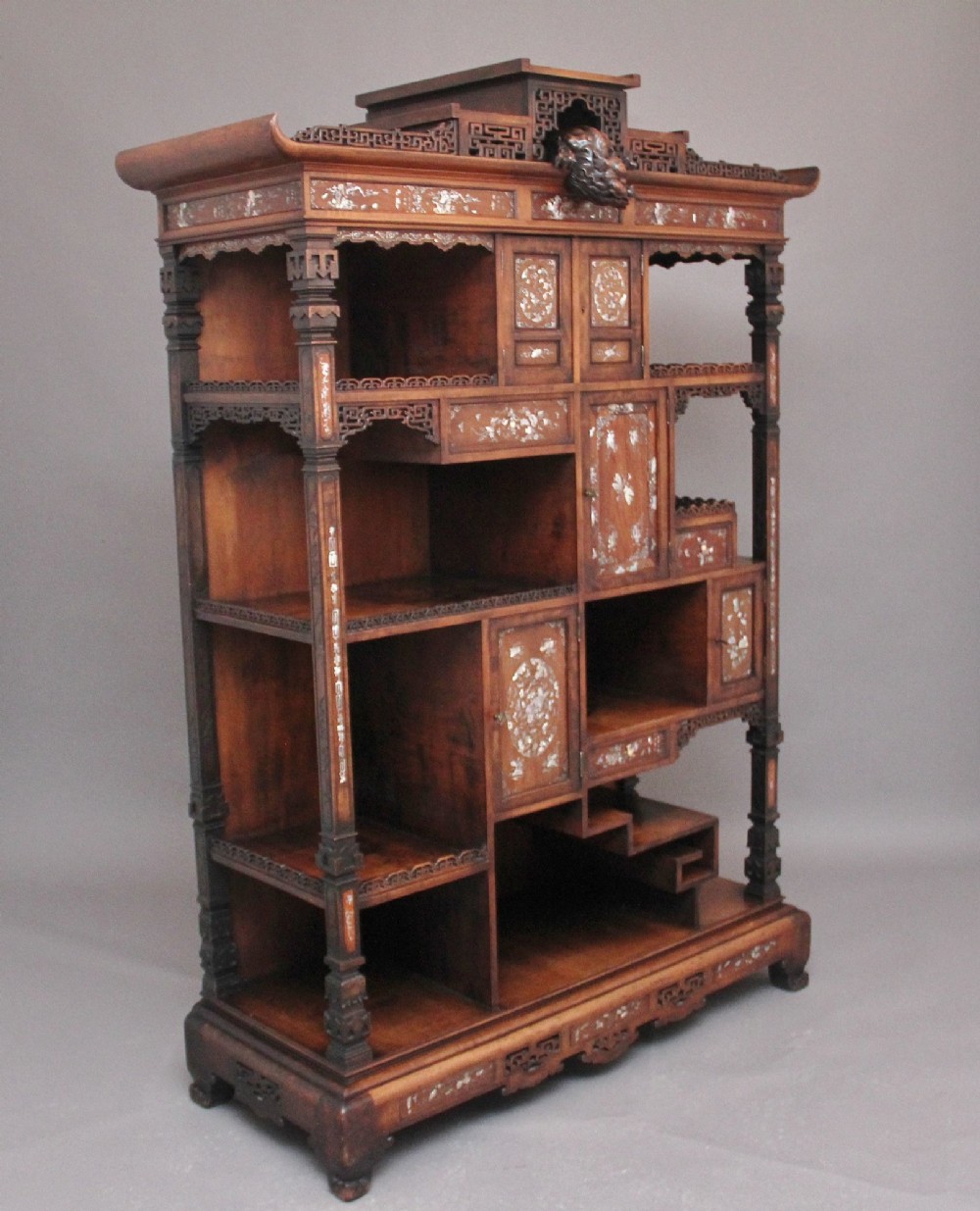 A dark brown 19th-century French Japonisme shodona display cabinet featuring mother-of-pearl inlays, asymmetrical shelves, and a carved pagoda crest with a dragon detail. View VII