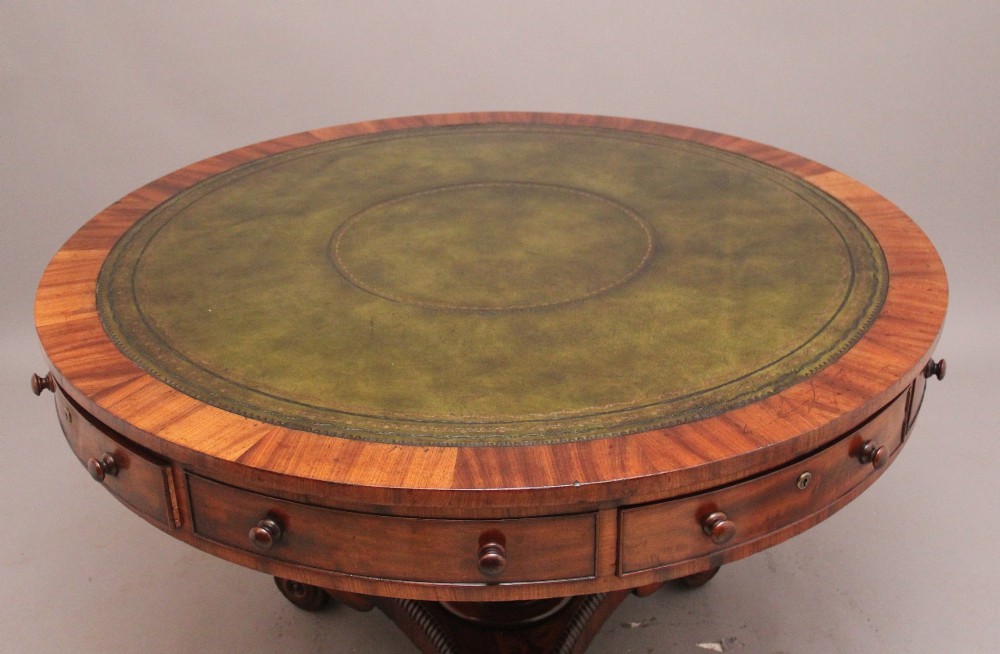 An early 19th century circular mahogany drum table featuring an inset green leather top, frieze drawers with knob handles, and a turned pedestal base. View II