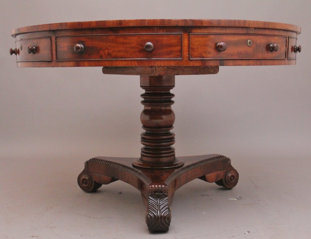 An early 19th century circular mahogany drum table featuring an inset green leather top, frieze drawers with knob handles, and a turned pedestal base. View IV