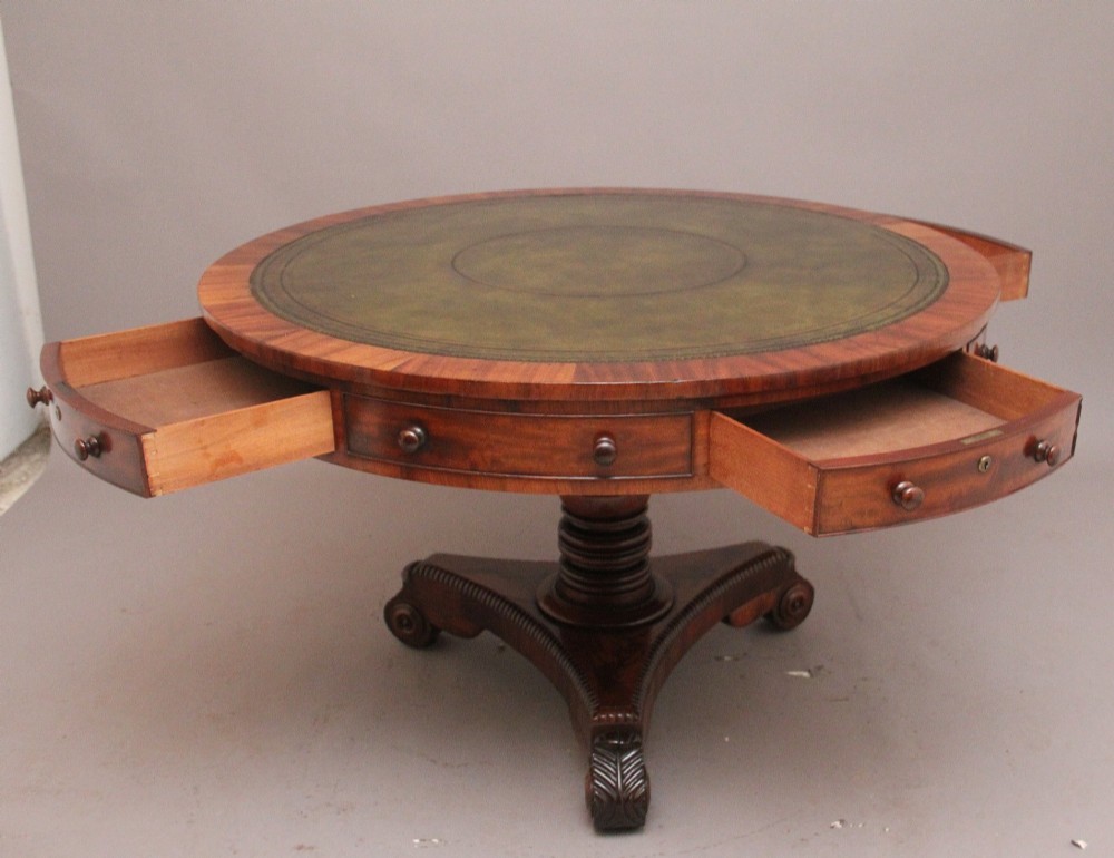 An early 19th century circular mahogany drum table featuring an inset green leather top, frieze drawers with knob handles, and a turned pedestal base. View V