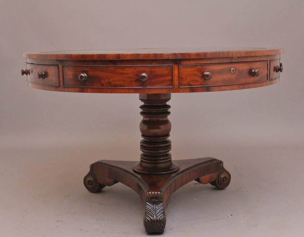 An early 19th century circular mahogany drum table featuring an inset green leather top, frieze drawers with knob handles, and a turned pedestal base. View VI