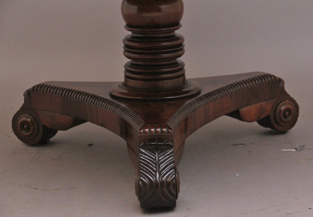 An early 19th century circular mahogany drum table featuring an inset green leather top, frieze drawers with knob handles, and a turned pedestal base. View VII