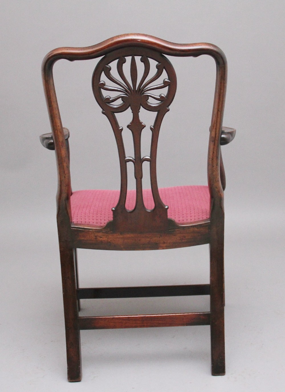 A set of ten dark mahogany armchairs featuring carved anthemion splats and red patterned upholstered seats. View V