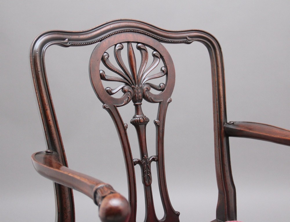 A set of ten dark mahogany armchairs featuring carved anthemion splats and red patterned upholstered seats. View IX