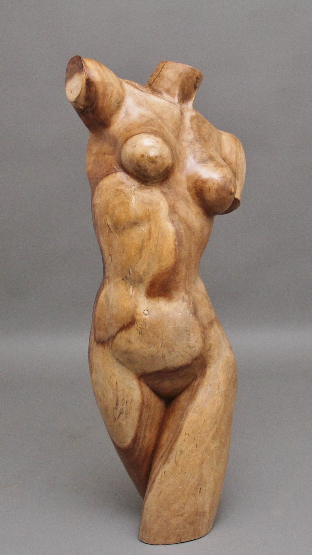 A life-size early twentieth-century sculpture of a female torso carved from natural timber with visible wood grain and a smooth finish. View II