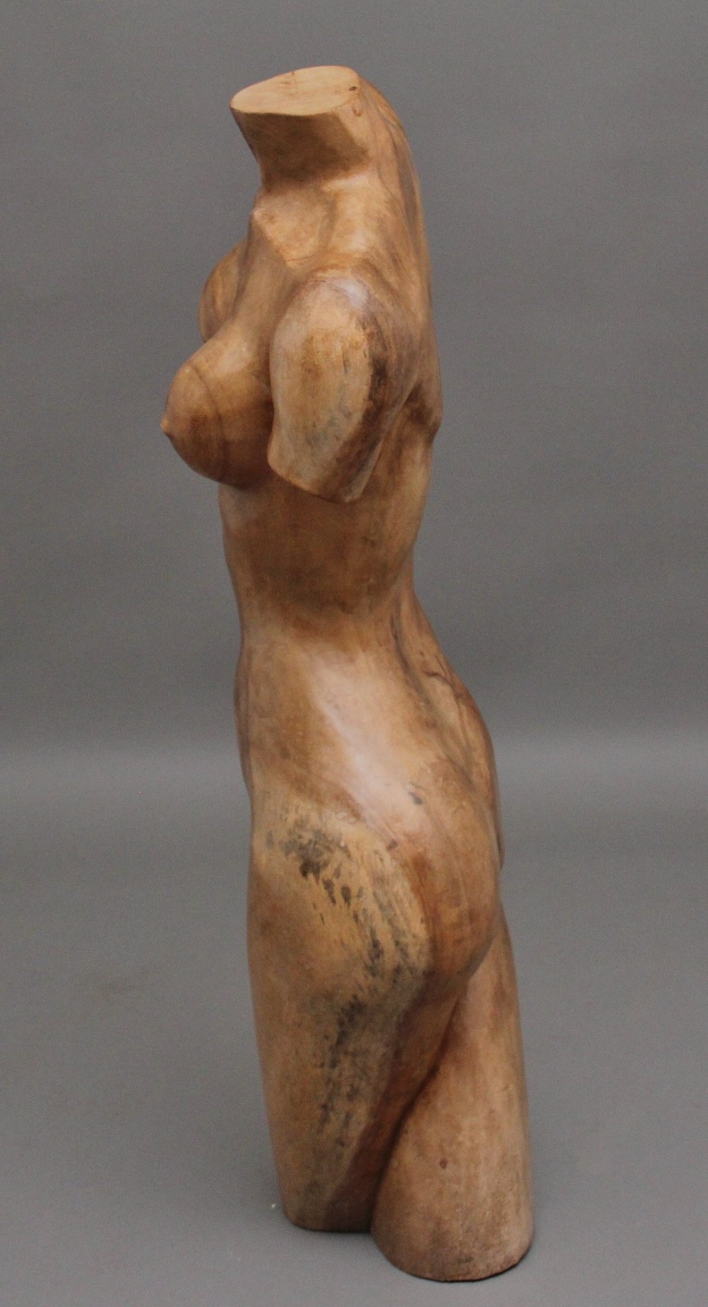 A life-size early twentieth-century sculpture of a female torso carved from natural timber with visible wood grain and a smooth finish. View V