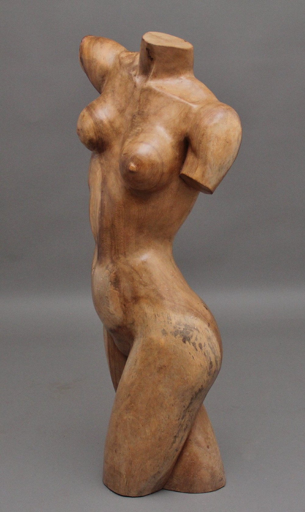 A life-size early twentieth-century sculpture of a female torso carved from natural timber with visible wood grain and a smooth finish. View VI