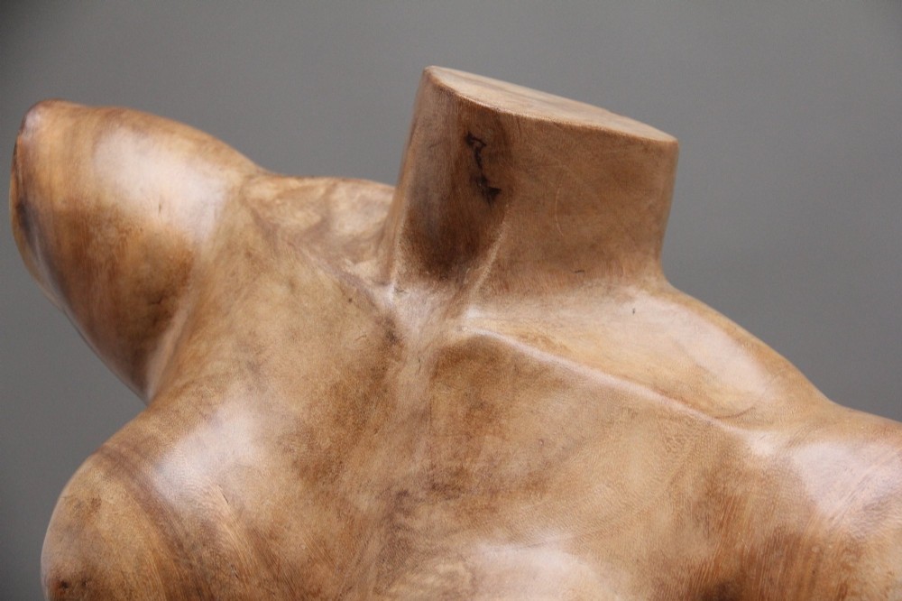 A life-size early twentieth-century sculpture of a female torso carved from natural timber with visible wood grain and a smooth finish. View VIII