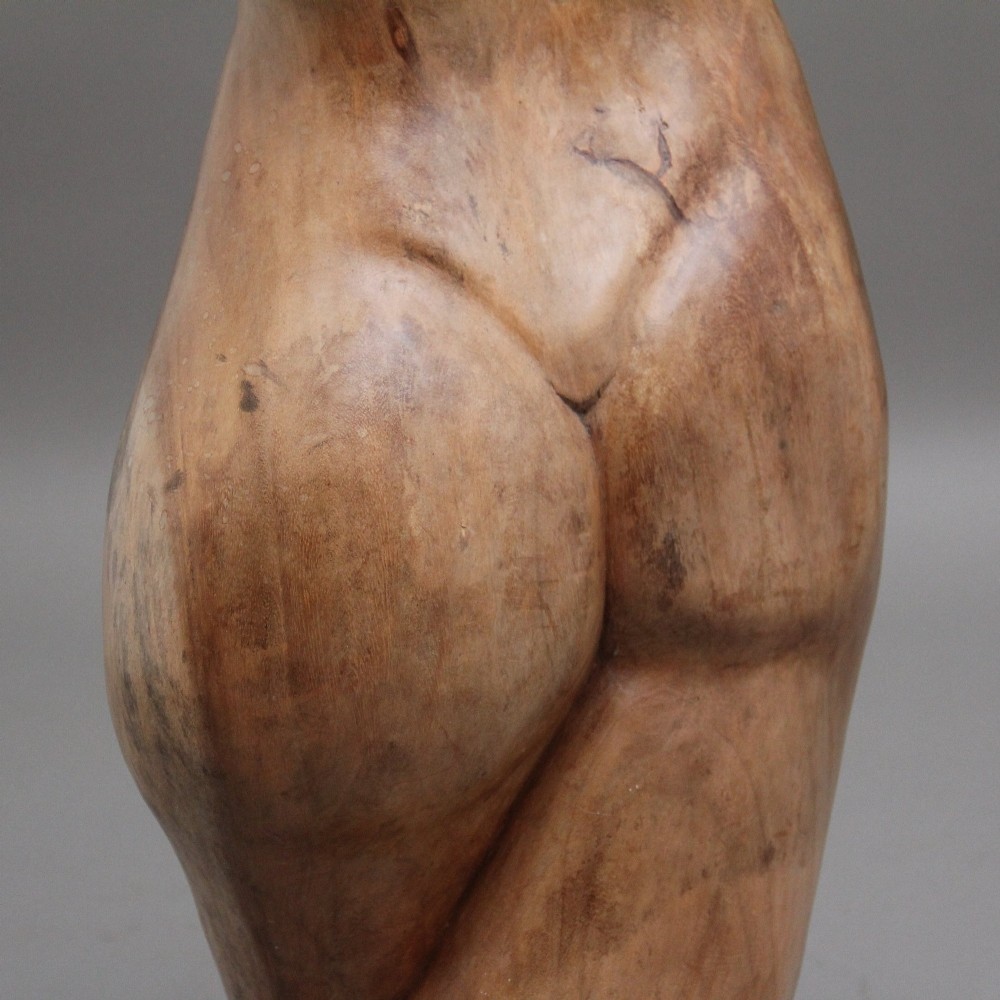 A life-size early twentieth-century sculpture of a female torso carved from natural timber with visible wood grain and a smooth finish. View XV