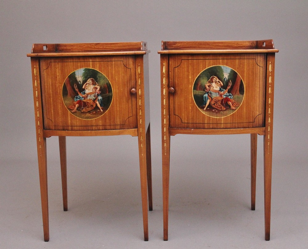 A pair of tall early 20th-century satinwood bedside cabinets featuring hand-painted classical figural medallions and tapered square legs. View II