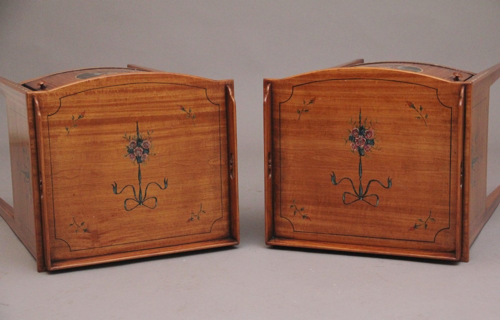A pair of tall early 20th-century satinwood bedside cabinets featuring hand-painted classical figural medallions and tapered square legs. View X