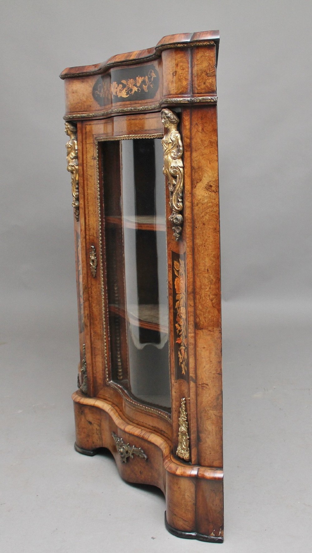 A Victorian burr walnut credenza featuring central floral marquetry, curved side glass doors, and gilt metal mounts. View VIII