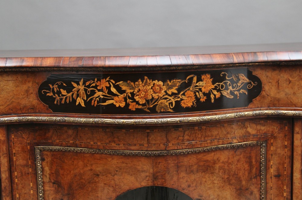 A Victorian burr walnut credenza featuring central floral marquetry, curved side glass doors, and gilt metal mounts. View XII
