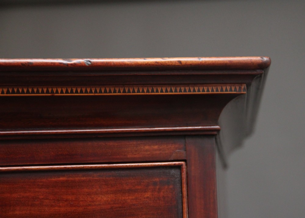An early nineteenth-century mahogany bow-front tallboy featuring seven stacked drawers with turned brass handles. View VI