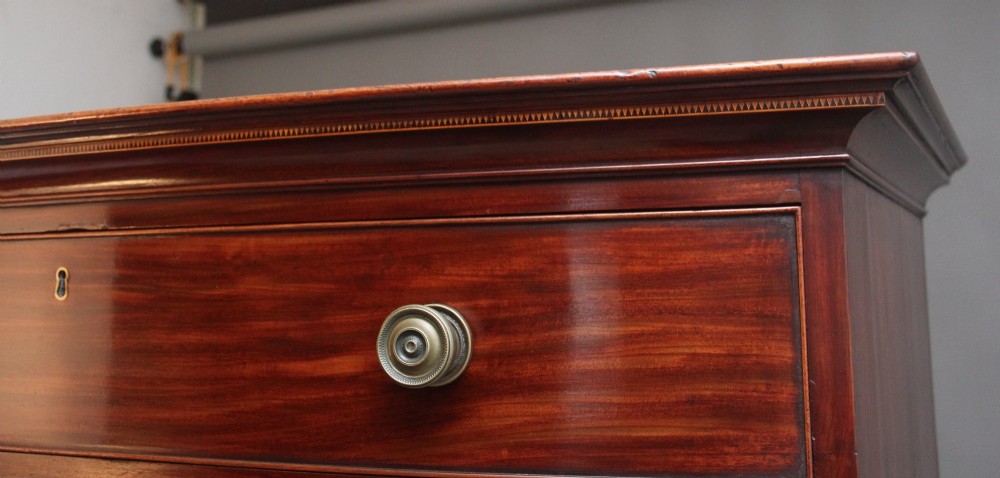 An early nineteenth-century mahogany bow-front tallboy featuring seven stacked drawers with turned brass handles. View VII