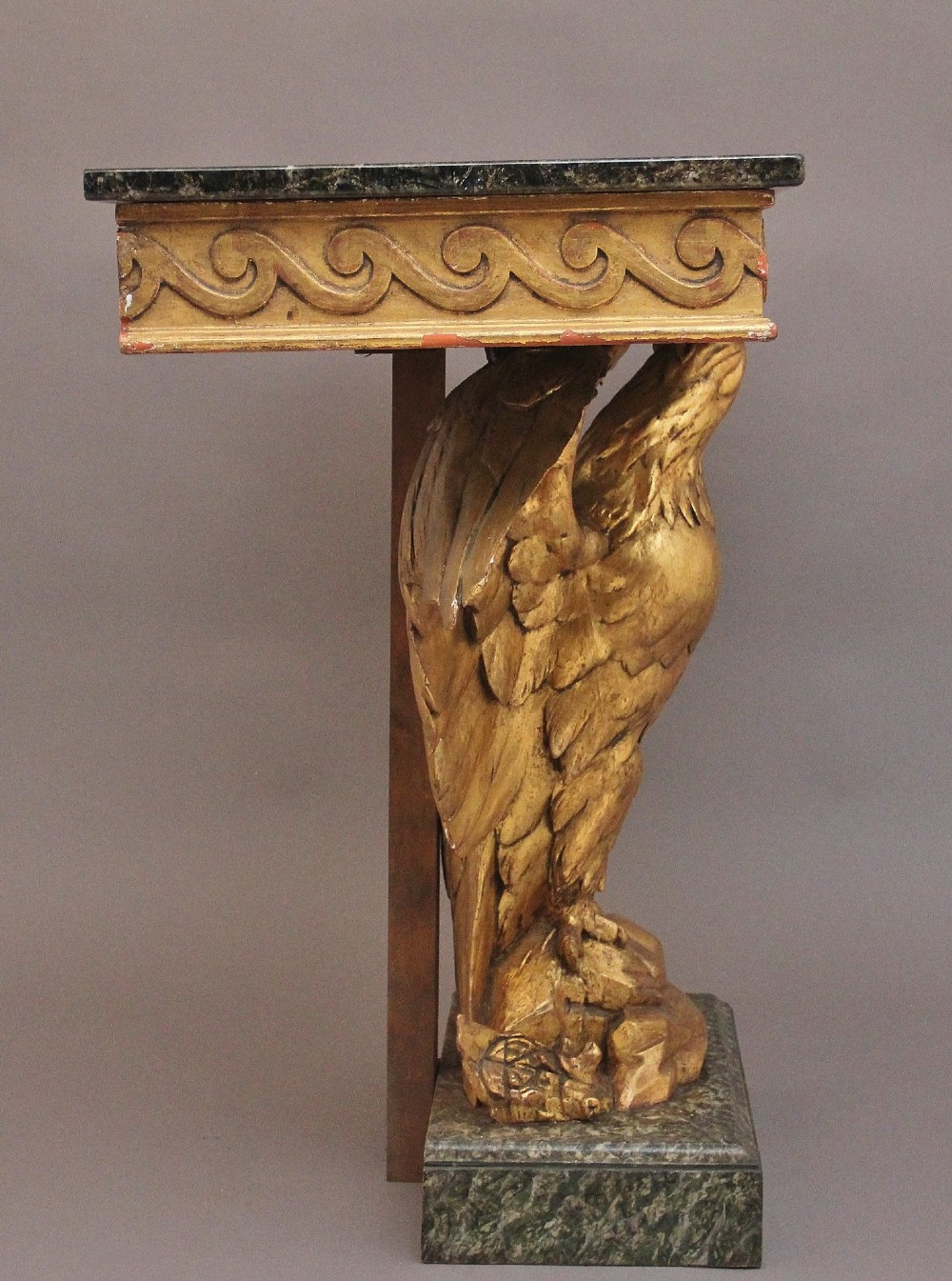 An early 20th-century Neoclassical style console table featuring a sculpted gold eagle base supporting a dark green marble tabletop. View VI
