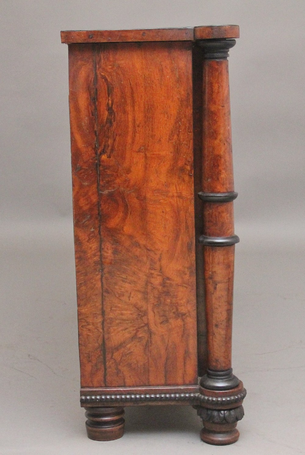 An early nineteenth-century Regency pollard oak side cabinet featuring ebony inlay, twin brass lattice grille doors with fabric backings, and side columns. View V