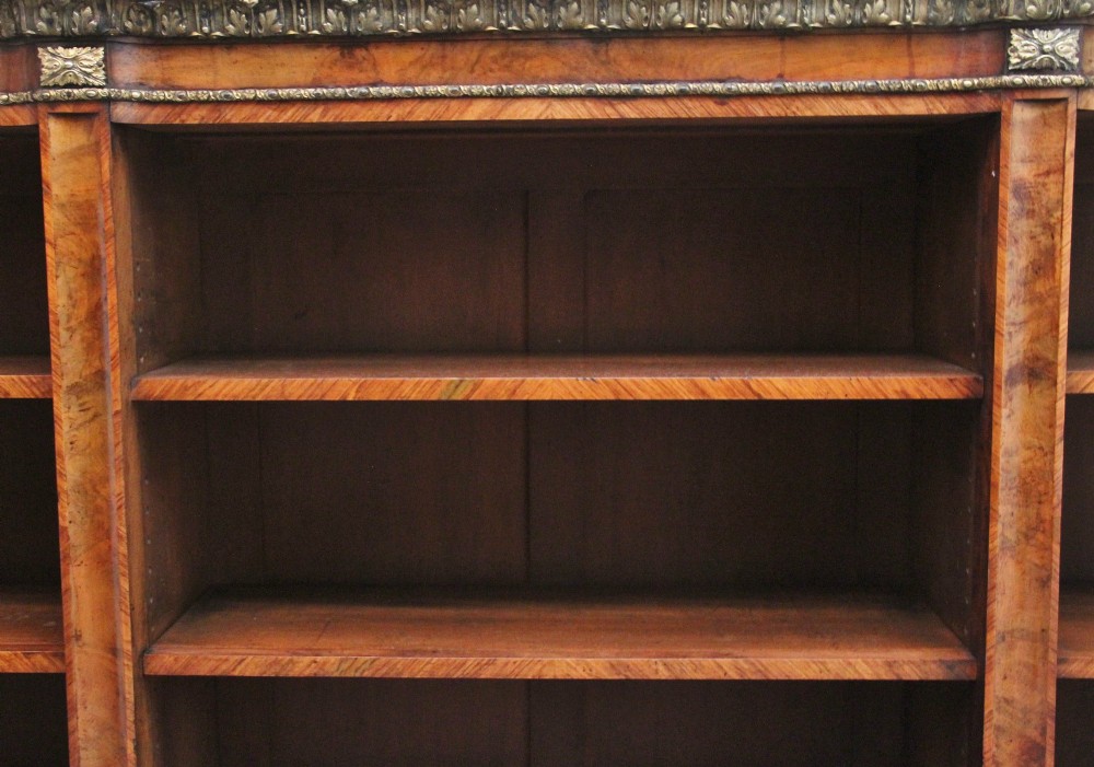 A nineteenth-century low breakfront open bookcase crafted from burr walnut with gilt-bronze ormolu mounts along the top border and base. View II