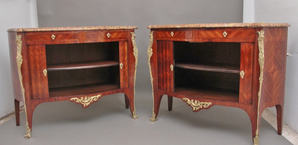 A pair of 19th-century French kingwood commodes featuring chevron parquetry veneer, mottled brown marble tops, and decorative gilt-bronze mounts. View IV