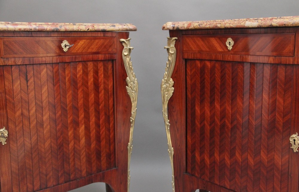 A pair of 19th-century French kingwood commodes featuring chevron parquetry veneer, mottled brown marble tops, and decorative gilt-bronze mounts. View XI