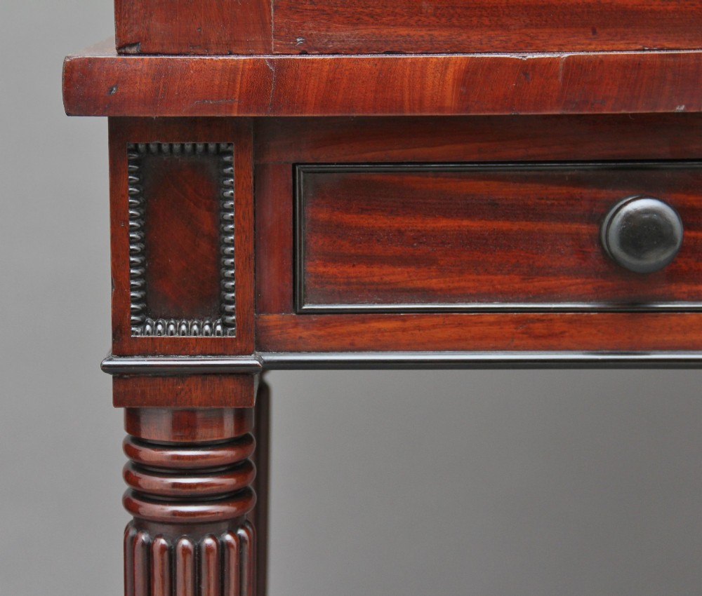 An early nineteenth-century flame mahogany collectors cabinet on stand featuring twin panelled doors above a single drawer and turned reeded legs. View XIV