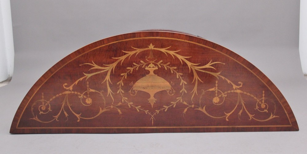 A 19th-century bow-fronted mahogany side cabinet featuring detailed satinwood marquetry panels with classical figures and swags on turned tapered legs. View V