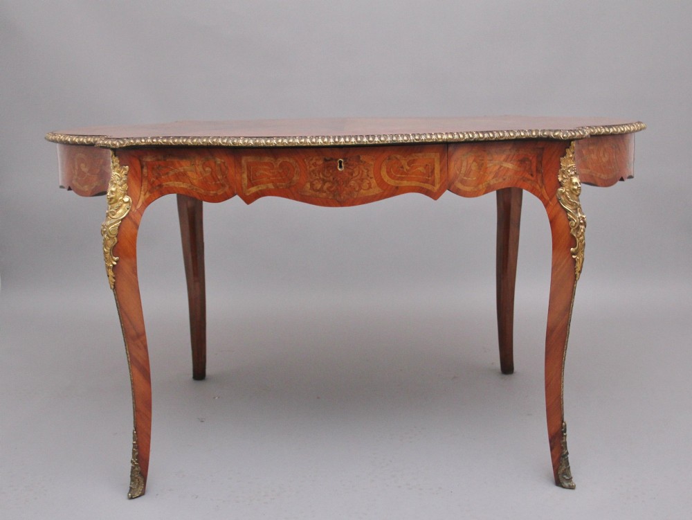 A 19th-century French style walnut centre table featuring elaborate marquetry inlay, a serpentine apron, cabriole legs, and ornate gilt bronze mounts.