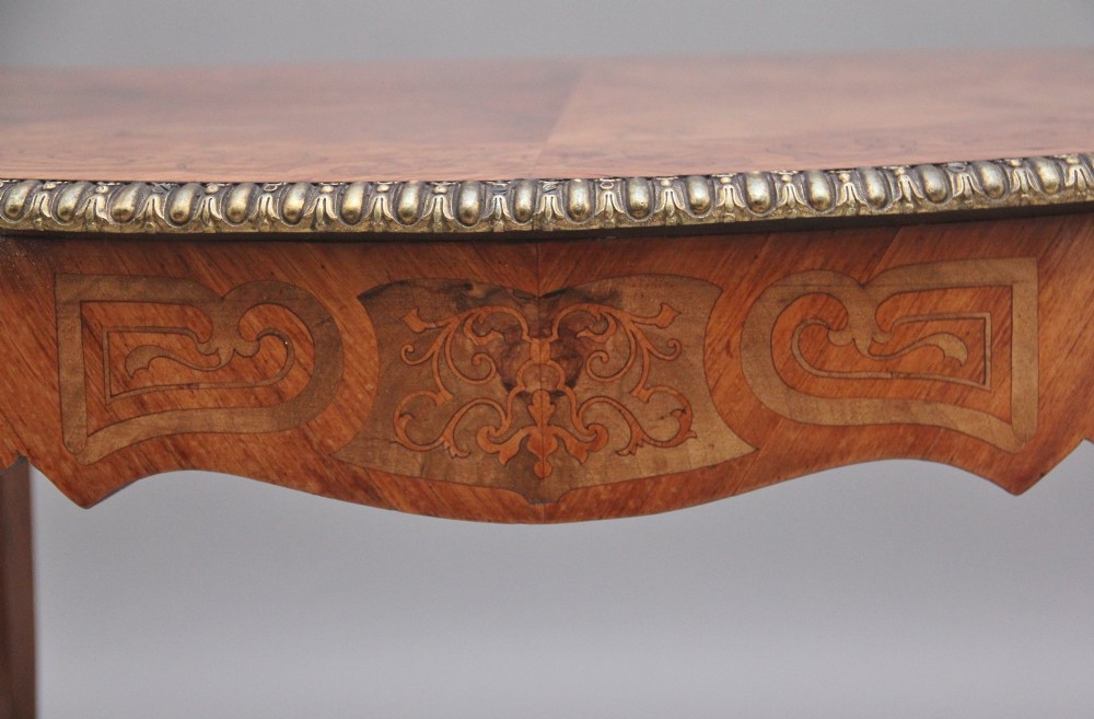 A 19th-century French style walnut centre table featuring elaborate marquetry inlay, a serpentine apron, cabriole legs, and ornate gilt bronze mounts. View XI