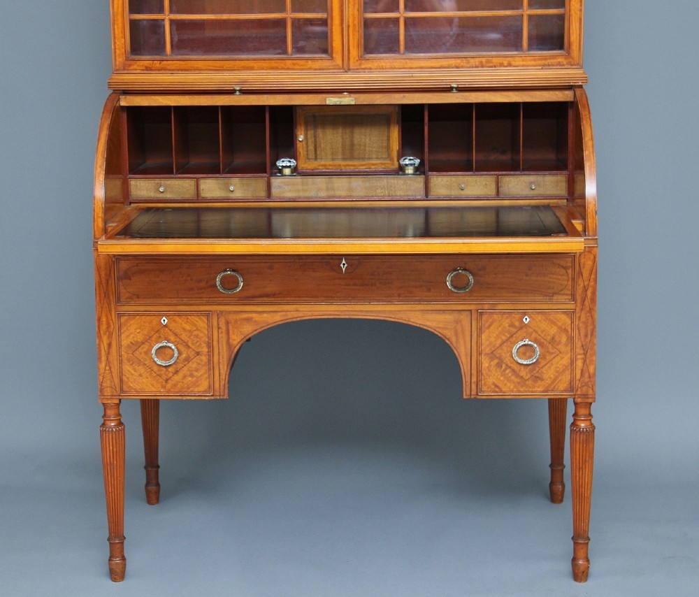A 19th-century satinwood cylinder bureau bookcase featuring upper glazed doors, a roll-top writing section, lower drawers, and turned fluted legs. View III