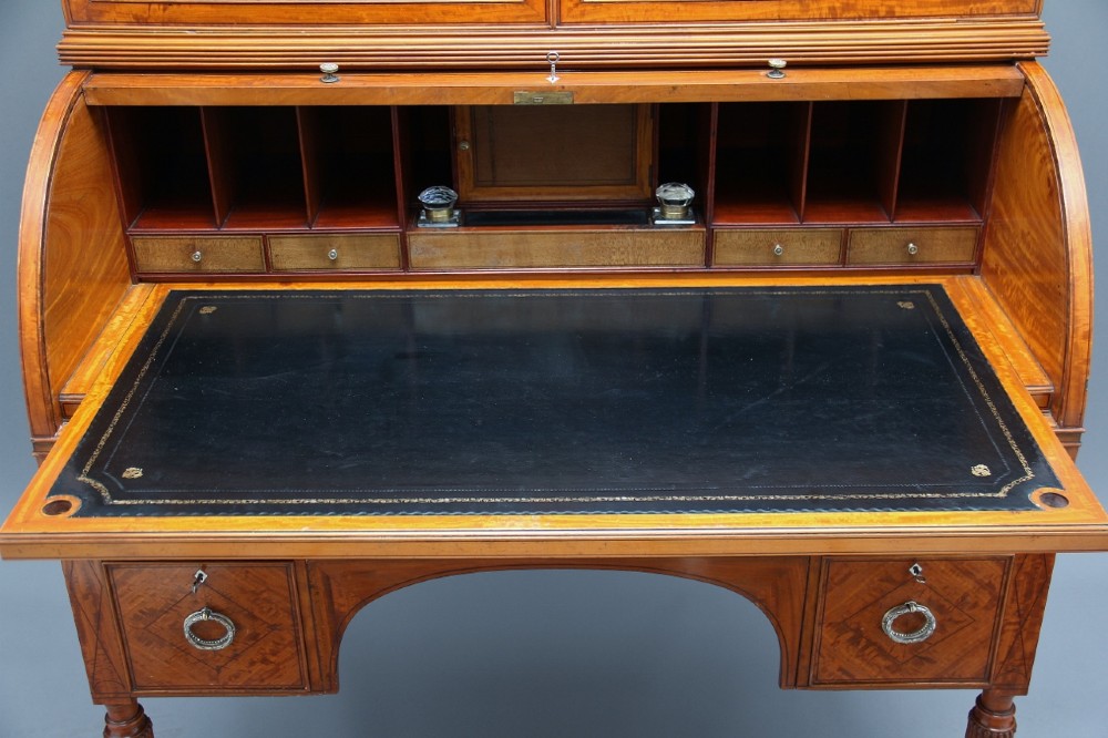 A 19th-century satinwood cylinder bureau bookcase featuring upper glazed doors, a roll-top writing section, lower drawers, and turned fluted legs. View IV