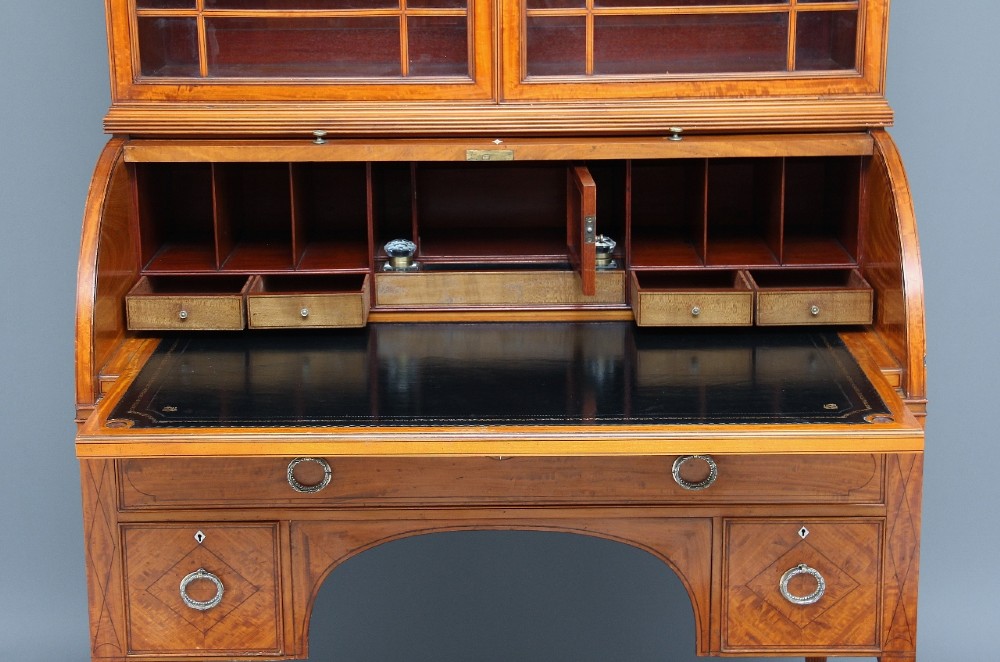 A 19th-century satinwood cylinder bureau bookcase featuring upper glazed doors, a roll-top writing section, lower drawers, and turned fluted legs. View XIII
