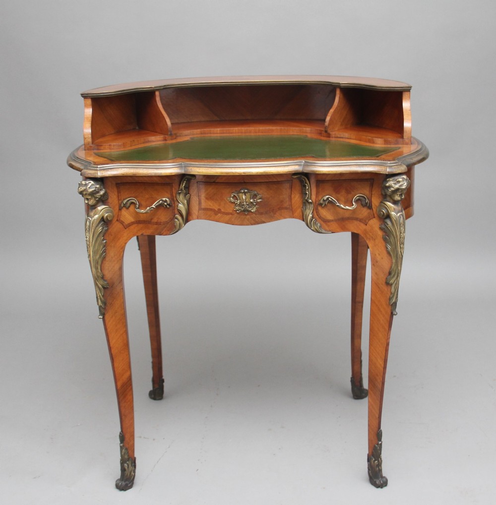 A 19th-century kingwood writing table featuring decorative gilt-bronze ormolu mounts, cabriole legs, a green leather writing surface, and a raised superstructure with pigeonholes. View III