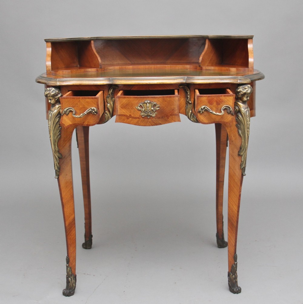 A 19th-century kingwood writing table featuring decorative gilt-bronze ormolu mounts, cabriole legs, a green leather writing surface, and a raised superstructure with pigeonholes. View IV