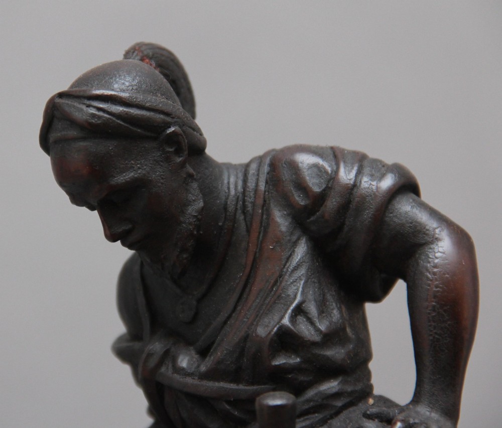 A nineteenth-century dark carved wood sculpture depicting a figure in flowing robes riding a trotting camel mounted on an oval base. View XI