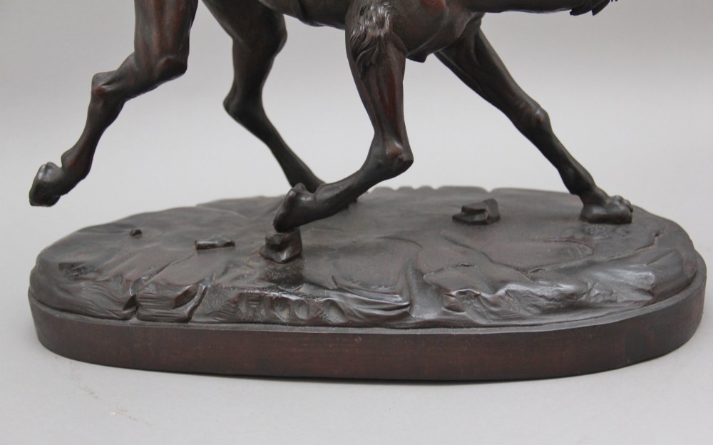 A nineteenth-century dark carved wood sculpture depicting a figure in flowing robes riding a trotting camel mounted on an oval base. View XII